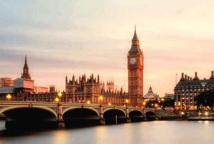 Westminster Bridge spanning the River Thames with Big Ben and the Houses of Parliament illuminated at sunset