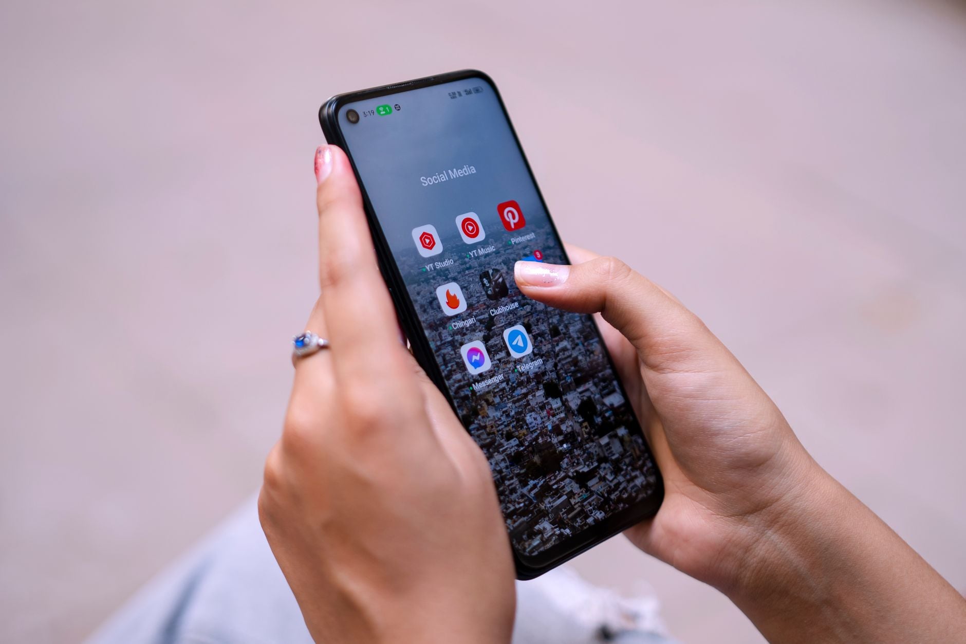 Kobieta trzymająca smartfon z ikonami aplikacji mediów społecznościowych na ekranie.